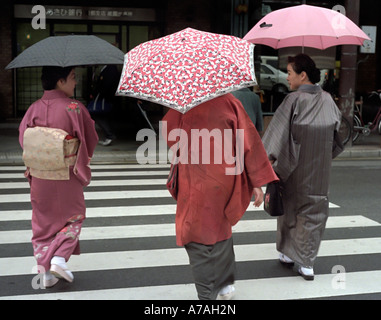 Trois woman wearing kimonos traditionnels dans le quartier commerçant de Kyoto Banque D'Images