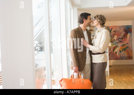 Mature couple kissing près de fenêtre de leur vacances homme avec assurance Banque D'Images