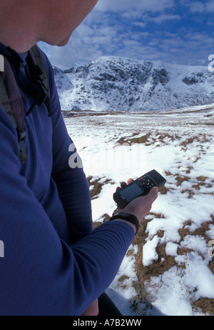 Walker en utilisant un GPS de poche sur Helvellyn la troisième plus haut sommet dans le Lake District en Angleterre Banque D'Images