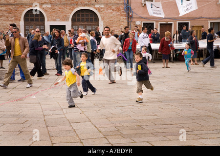 Les enfants courir à course de rue dans le cadre du festival à Merletto île de Venise Banque D'Images