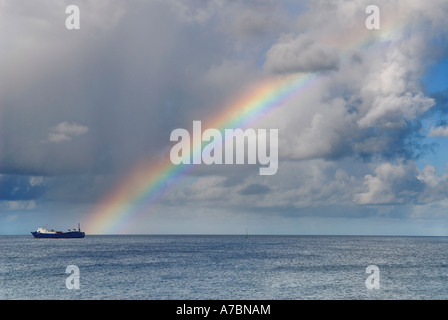 Arc-en-ciel sur la mer des Caraïbes se terminant à un cargo Saint Martin Antilles Néerlandaises Little Bay Banque D'Images