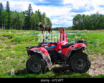 Enfant Le Quad en Alberta Canada avec son lévrier irlandais en arrière-plan. Banque D'Images