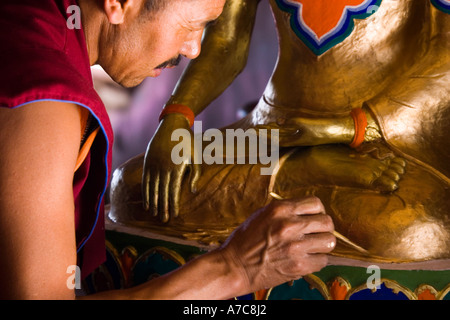 Jeune moine paiting un bouddha à l'intérieur de monastère Thiksey Ladakh Himalaya Indien Banque D'Images