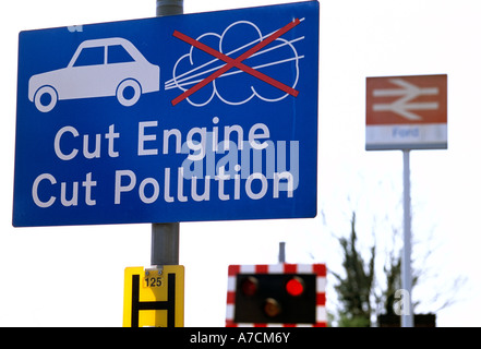 Réduire la pollution moteur signe à un passage à niveau, Ford, West Sussex, Angleterre, Royaume-Uni. Banque D'Images