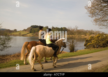 LLANDECWYN GWYNEDD AU NORD DU PAYS DE GALLES UK Avril Deux jeunes femmes équitation leurs poneys autour du très toujours Llyn Tecwyn Uchaf Banque D'Images