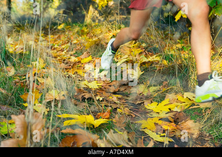 Jeune femme vu de taille en bas du jogging en couleurs d'automne Banque D'Images