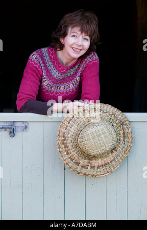 Anna Lewington avec chapeau fabriqué à partir de roseaux récoltés dans un traditionnel et durable de la rivière Stour, dans le Dorset, Angleterre Banque D'Images