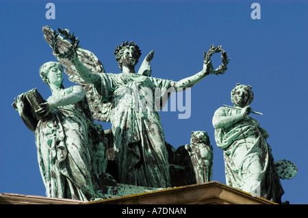 Statues en bronze oxydé au sommet du Teylers Museum à Haarlem, Hollande du Nord, avec des figures allégoriques sur un ciel bleu clair. Banque D'Images