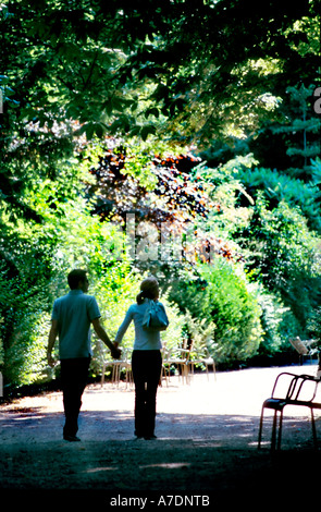 Paris romantique France, Parcs Jeune couple d'adolescents touristes adolescent Marchant main dans la main dans les "Jardins du Luxembourg" "Luxembourg Gardens" au printemps Banque D'Images