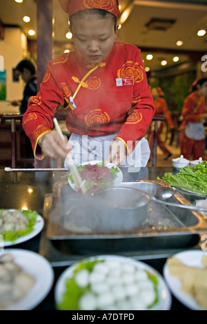 Chine CHONGQING Ingrédients pour Chongqing Potée plat traditionnel servi par des serveuses chinois attrayant Banque D'Images