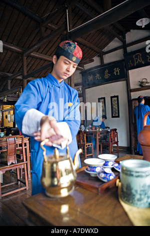 HANGZHOU, Chine thé jeune serveur atteint pour théière en laiton Banque D'Images