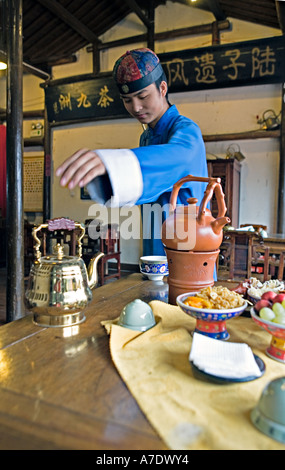 HANGZHOU, Chine thé jeune serveur atteint pour théière en laiton Banque D'Images