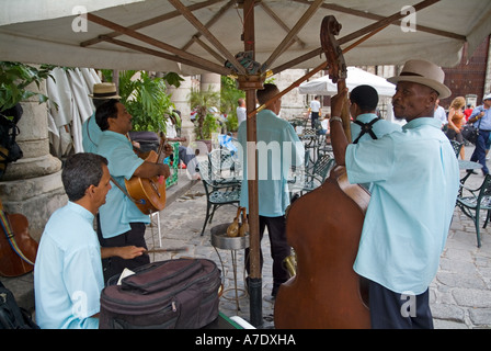 Les passants à l'hôtesse musiciens Taberna de la Muralla sur la Plaza Vieja, La Havane, Cuba. Banque D'Images