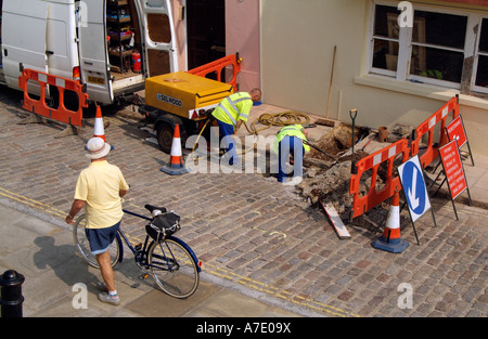 Travaux Ouvriers creusant un trou dans la route Angleterre fixant les tuyaux d'alimentation en eau Banque D'Images