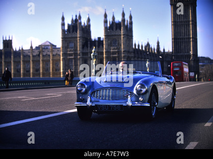 Une AUSTIN HEALEY PASSANT SUR LE PONT DE WESTMINSTER AVEC LE PALAIS DE WESTMINSTER À L'ARRIÈRE-PLAN Banque D'Images