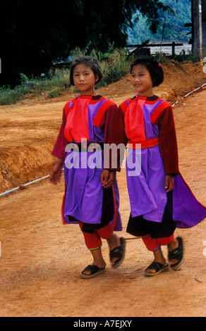 Deux jeunes filles portant des vêtements traditionnels Lisu marchant dans un chemin de boue Banque D'Images