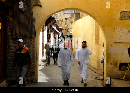 Vêtu du costume traditionnel des hommes à pied par une porte dans la vieille ville de Fès El-Bali Maroc Banque D'Images