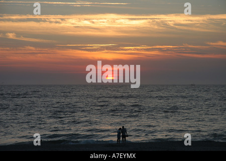 Un couple regarde le coucher du soleil sur la plage de Sylt, Schleswig-Holstein, Allemagne Banque D'Images