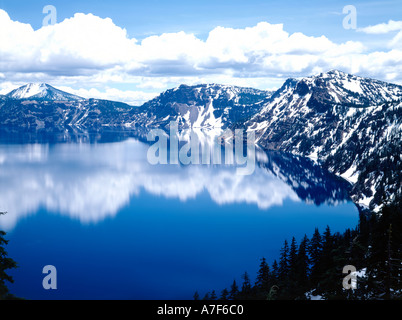 Crater Lake National Park dans le sud de l'Oregon reflète l'eau miroitant et pics enneigé Deep blue sky Banque D'Images