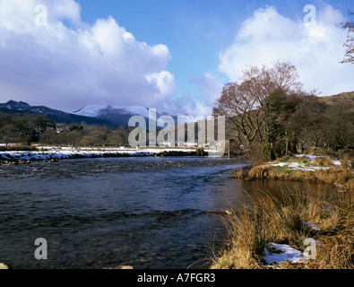 Le NORD DU PAYS DE GALLES DE BEDDGELERT GWYNEDD UK Mar à la recherche de l'autre côté de la rivière Glaslyn vers le village sur un jour de neige Banque D'Images