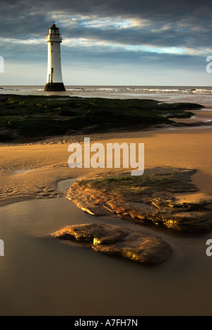 Virtical Photo du nouveau phare de Brighton avec rochers en premier plan dans la lumière du soleil d'or, situé sur la Péninsule de Wirral Banque D'Images