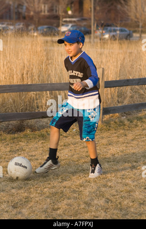 Boy joue au soccer dans Winnemac Park, Chicago, IL Banque D'Images