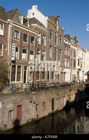 Maisons hollandaises traditionnelles le long de l'Oude Gracht ou du Vieux canal à Utrecht, Hollande, avec des vélos garés sur la rive sous un ciel bleu clair. Banque D'Images