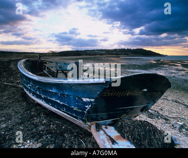 Droit de l'atmosphère d'une épave de vieux bateau sur la plage en plan échoue à Thorness bay au coucher du soleil près de Cowes Grondin et l'île de Wight, Angleterre, RU Banque D'Images