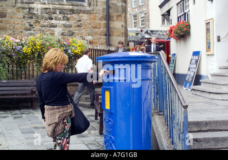 M. FEMME POSTANT UN COURRIER DANS UNE BOÎTE AUX LETTRES BLEUE PILIER ST-PETER PORT GUERNESEY CHANNEL ISLANDS GRANDE-BRETAGNE Banque D'Images