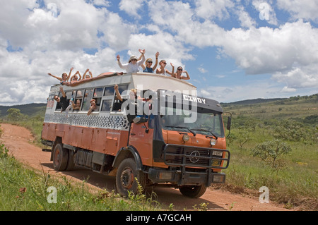 Une maison de l'aventure terrestre camion avec heureux touristes forme tout en voyageant le long d'un chemin de terre en direction de Brasilia. Banque D'Images