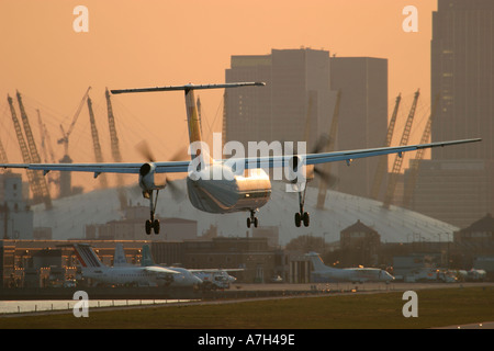 British European Dash 8 à l'atterrissage à l'aéroport de London City avec Millenium Dome dans l'arrière-plan 2004 Banque D'Images