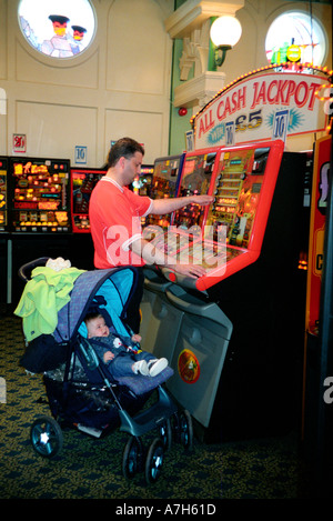 L'homme et l'enfant en jeux d'arcade jouer sur les machines à sous. Banque D'Images