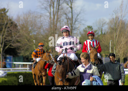 Pas de cheval, fantaisiste en rouge Golden Dixie en orange avec les entraîneurs et les jockeys à Kempton Park Banque D'Images