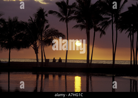 N.A., USA, Hawaii, Big Island, couple, palmiers et le coucher du soleil se reflétant dans lagon à la baie d'Anaeho'omalu Banque D'Images