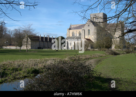 St Croix, abbaye, Winchester, Hampshire vu à travers l'eau des prairies. Banque D'Images