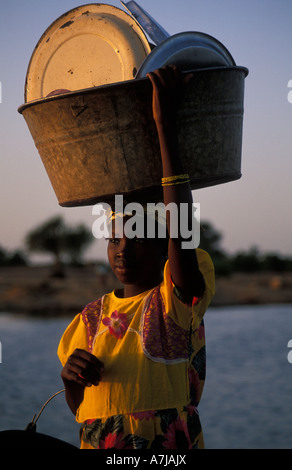 Fille Peul transportant sa vaisselle à laver dans le fleuve, Djenné, Mali Banque D'Images