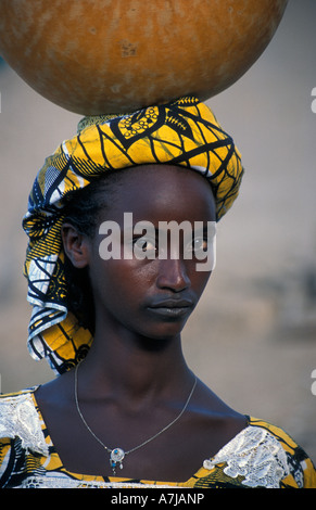 Femme Peul avec tatouage bouche caractéristique portant de l'eau, Djenné, Mali Banque D'Images