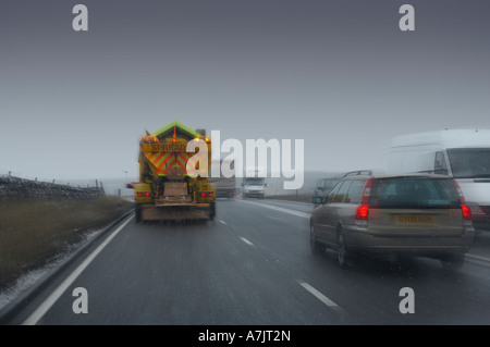 Le sablage DES JAUNES AVEC CAMION CHASSE-NEIGE, RÉPANDRE DU SABLE ET GRAVIER SUR LA ROUTE DU SEL Banque D'Images