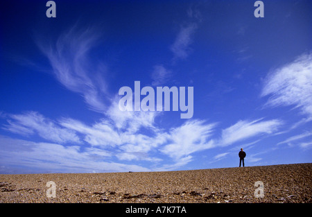 Homme debout sur l'horizon sur la côte pavée à plage de Chesil Dorset angleterre Europe Banque D'Images