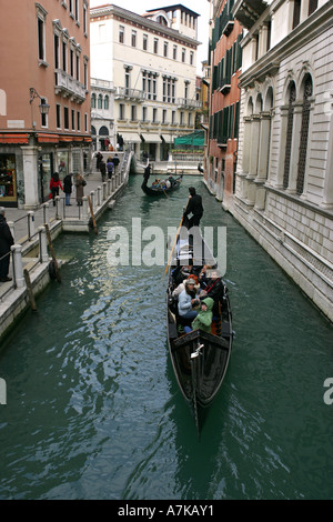 Les touristes profiter d'une excursion en bateau traditionnel ride dans une gondole vénitienne sur un canal de Venise, Vénétie Italie Europe EU Banque D'Images