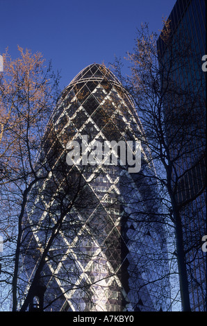 Le Gherkin (AKA 30 St Mary Axe ou Swiss Re building) vue à travers Londres platanes, City of London Banque D'Images