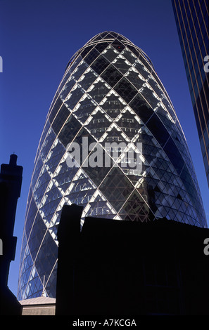 Le Gherkin (AKA 30 St Mary Axe ou anciennement Swiss Re building) avec silhouette de bâtiments victoriens et pots de cheminée, Londres Banque D'Images