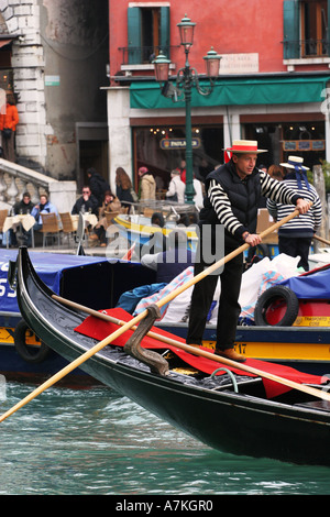 Libre d'être gondolars vénitien punted par des hommes en robes stripey typique sur le Grand Canal, Venise Italie Europe EU Banque D'Images