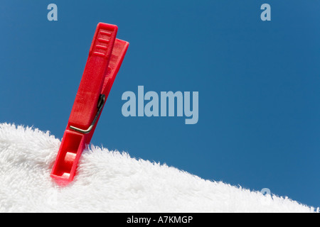 Vêtements peg sur une serviette blanche et lave-line against a blue sky Banque D'Images