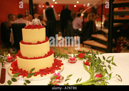 Moderne à trois niveaux gâteau de mariage décoré avec caractère chocolat blanc mariée et le marié donne sur réception de mariage petit-déjeuner Banque D'Images