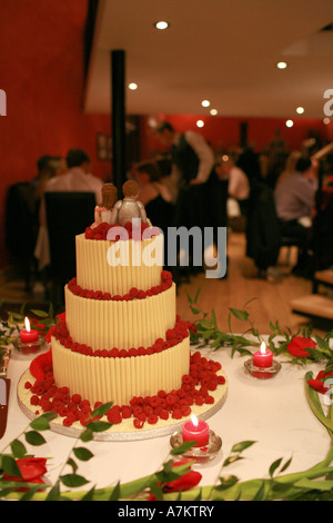 Moderne à trois niveaux gâteau de mariage décoré avec caractère chocolat blanc mariée et le marié donne sur réception de mariage petit-déjeuner Banque D'Images