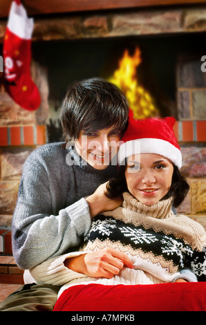 Jeune Fille habillée en père Noël assis avec son petit ami à la maison. Banque D'Images