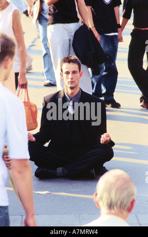 Jeune homme stitting sur la rue. Banque D'Images