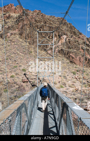 Female hiker traverse le pont d'argent sur le fleuve Colorado sur son chemin de la Phantom Ranch au bas du Grand Canyon Banque D'Images