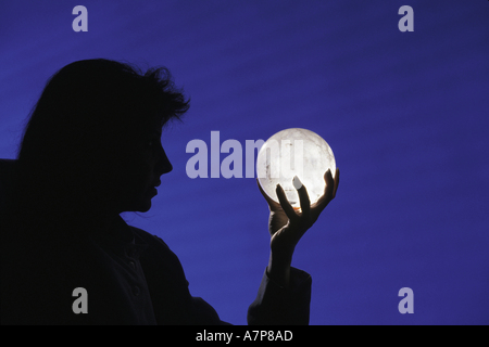 Silhouette d'une femme d'affaires tenant une boule de cristal afin de déterminer l'avenir de son entreprise Banque D'Images